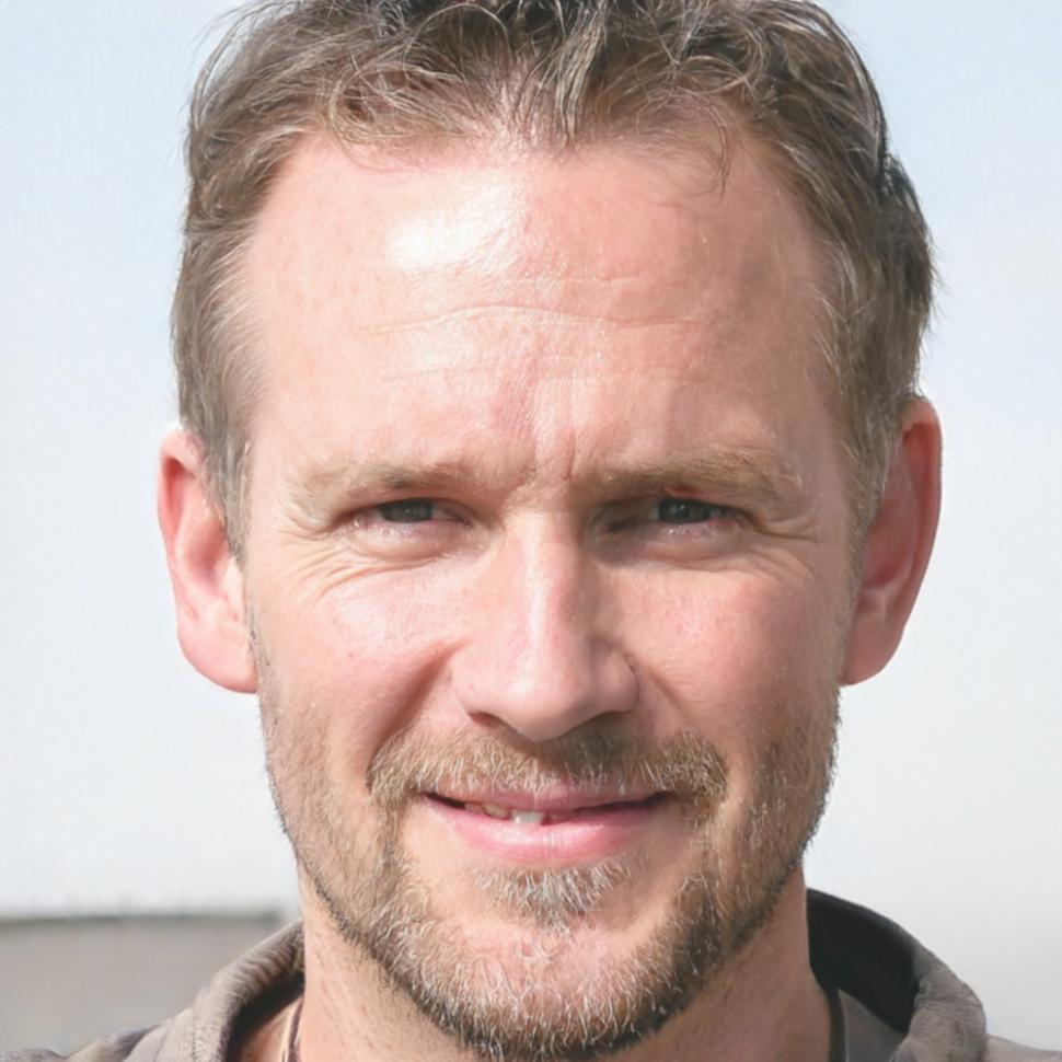 Dozent Fridolin Arendt sitzt an einem Schreibtisch mit Finanzunterlagen